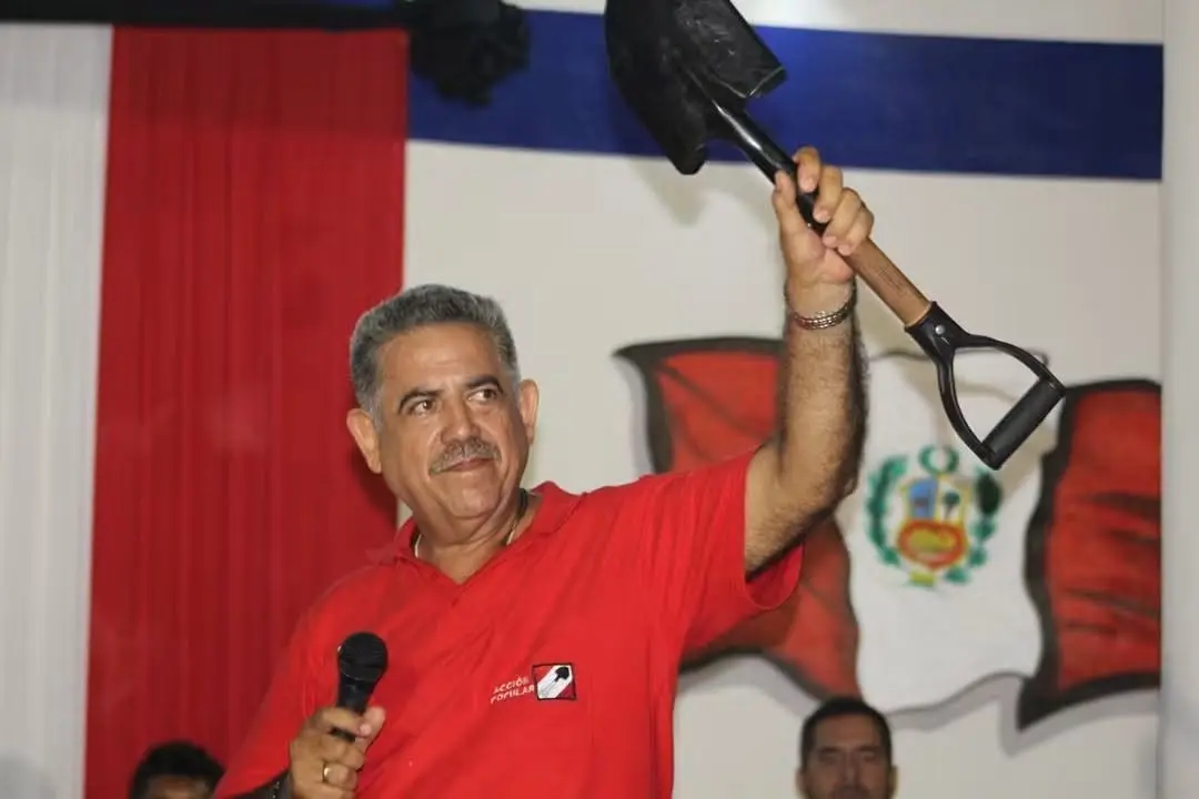 Manuel Merino de Lama levanta una pala, símbolo de Acción Popular, durante un evento del partido.